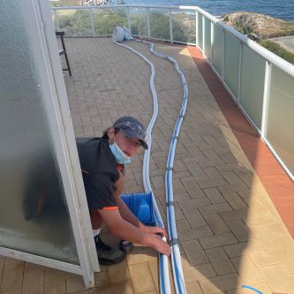 on a balcony working with ducted air conditioner pipes