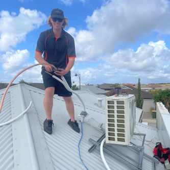 on a roof while installing a ducted air conditioning system