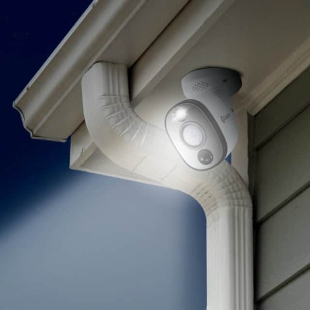 cctv security camera mounted below gutter with spotlight on